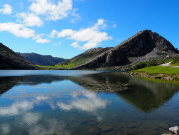 Scenic view of lake and mountains against blue sky