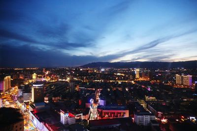 Illuminated cityscape against sky at night