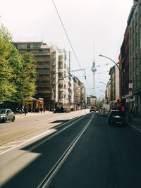 Cars on road in city against clear sky