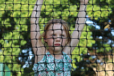 Portrait of girl seen through fence