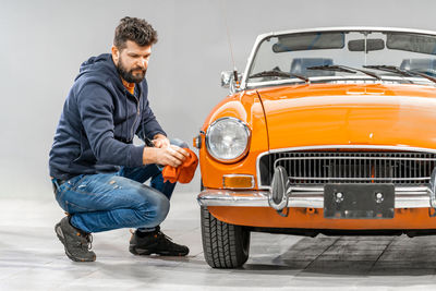 Side view of man holding car