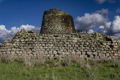 Stone structure on field against sky