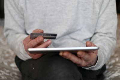 Midsection of man using mobile phone