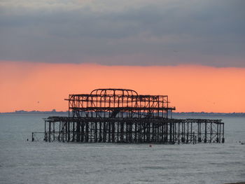 West pier in sea against sky during sunset at brighton