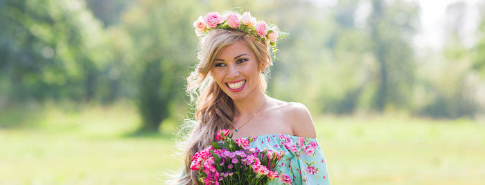 Portrait of smiling young woman against blue sky