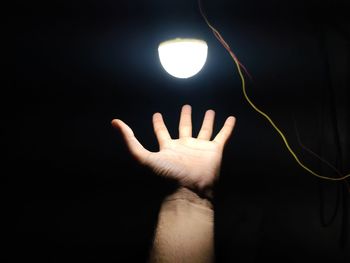 Midsection of person light painting against black background