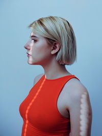 Portrait of beautiful young woman against blue background