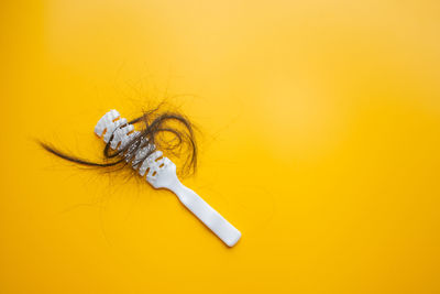 Close-up of cigarette smoking against yellow background