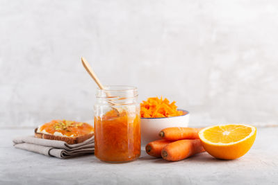 Orange fruit in glass jar on table