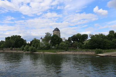 Scenic view of river by trees against sky