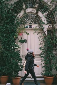 Rear view of woman walking by building