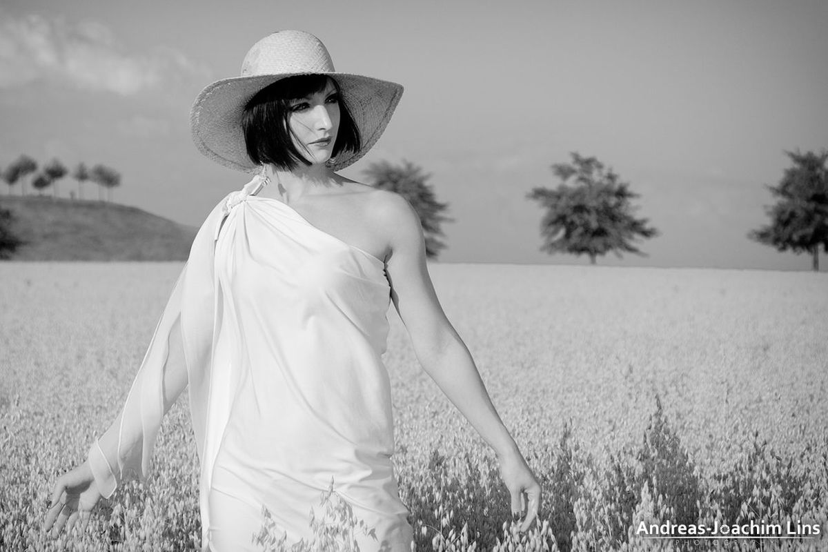 person, young adult, lifestyles, casual clothing, field, leisure activity, grass, portrait, looking at camera, smiling, front view, three quarter length, young women, sky, standing, landscape, tree, focus on foreground