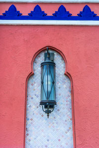 Low angle view of lantern on building wall