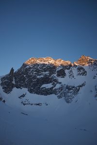 Scenic view of snowcapped mountains against clear blue sky