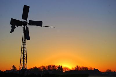 Low angle view of windmill at sunset