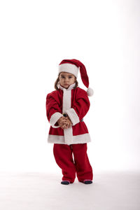 Portrait of boy wearing hat standing against white background