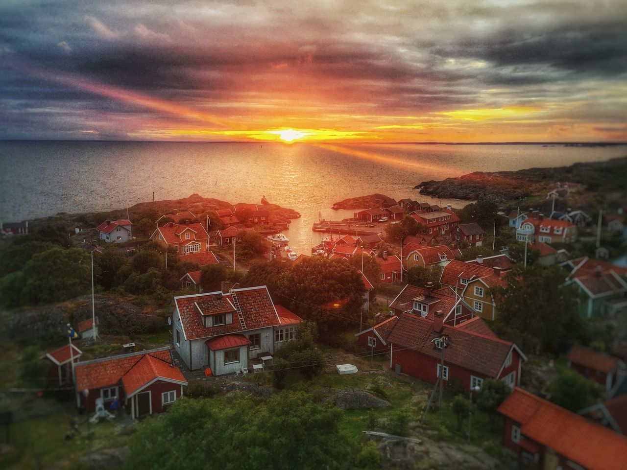 sunset, building exterior, architecture, sky, built structure, cloud - sky, high angle view, water, house, residential structure, cloudy, residential building, tree, residential district, city, cityscape, town, orange color, sea, townscape