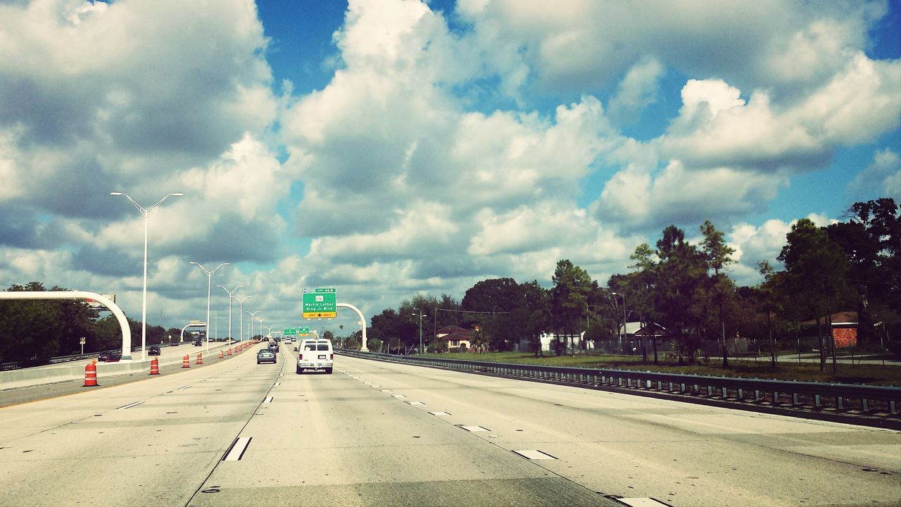 transportation, road, road marking, sky, the way forward, cloud - sky, mode of transport, land vehicle, car, cloudy, diminishing perspective, vanishing point, cloud, street, travel, tree, on the move, journey, day, highway