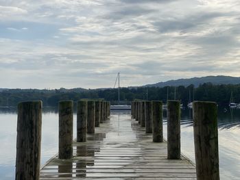 Wooden pier over sea against sky