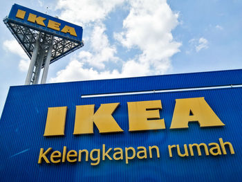 Low angle view of information sign against sky