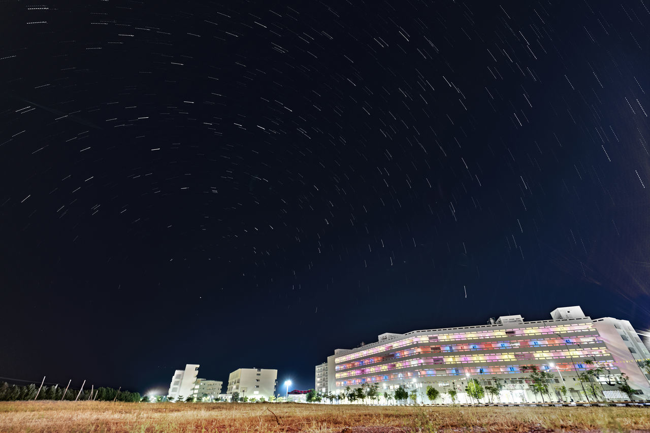 LOW ANGLE VIEW OF BUILDINGS AGAINST SKY AT NIGHT