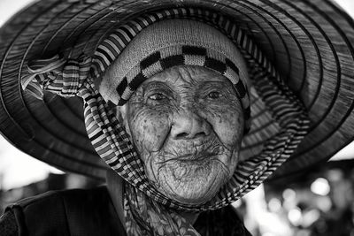 Close-up portrait of senior woman wearing asian style conical hat