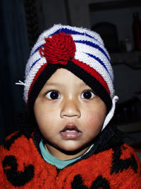 Close-up portrait of cute boy wearing knit hat against black backgrounds