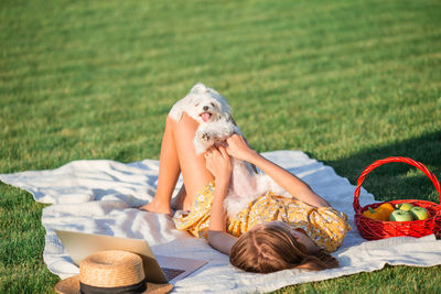 Woman with dog relaxing on field