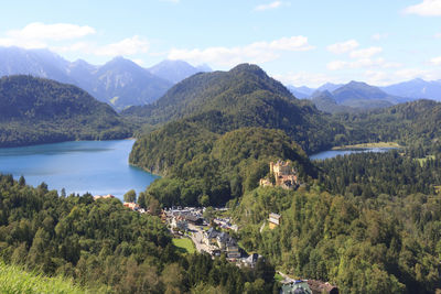 Scenic view of townscape by mountains against sky