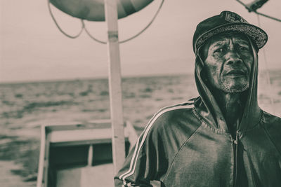 Portrait of man standing by sea against sky