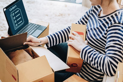 Midsection of woman using digital tablet