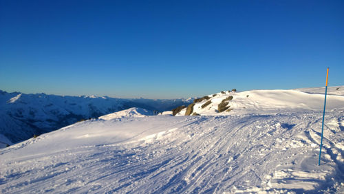 Scenic view of snowcapped mountains against clear blue sky