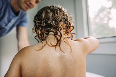 Father bathing daughter in bathroom