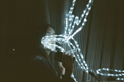 Woman holding illuminated lighting equipment