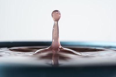 Close-up of water splashing on white surface