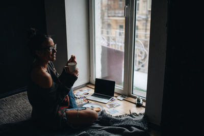Side view of woman having coffee at home