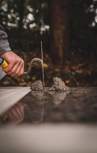 Cropped hand of construction worker using tool outdoors