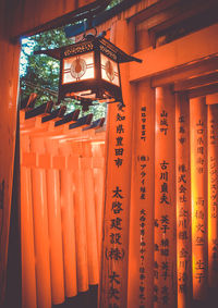 Low angle view of illuminated lanterns hanging from ceiling in temple