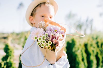 Young boy holding a beautiful bouquet of flowers