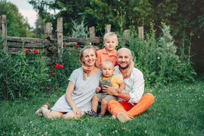 Portrait of family sitting on grass at park