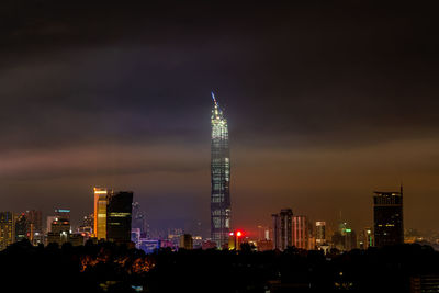 Illuminated buildings in city against sky at night