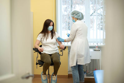 A nurse gives a vaccine to a girl. doctor and patient in a medical office