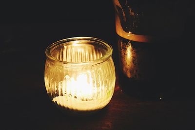 Close-up of illuminated lamp on table against black background