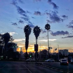 Road passing through city at sunset