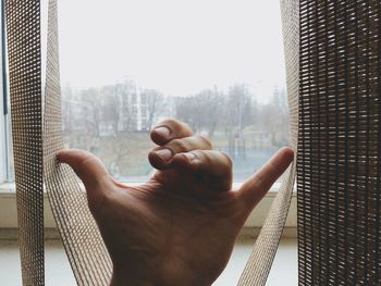 Close-up of man holding window at home