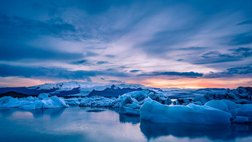 Scenic view of frozen lake against sky during sunset