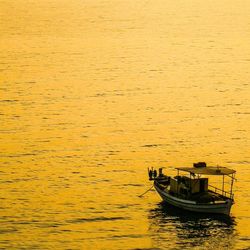 Boats in calm sea at sunset