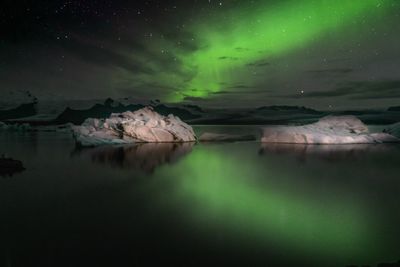 Scenic view of lake against sky at night