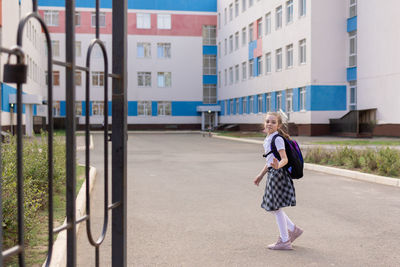 Back to school. girl in school uniform go to school with backpack behind their backs. beginning 