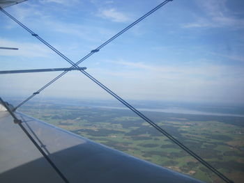 Airplane flying over landscape against sky